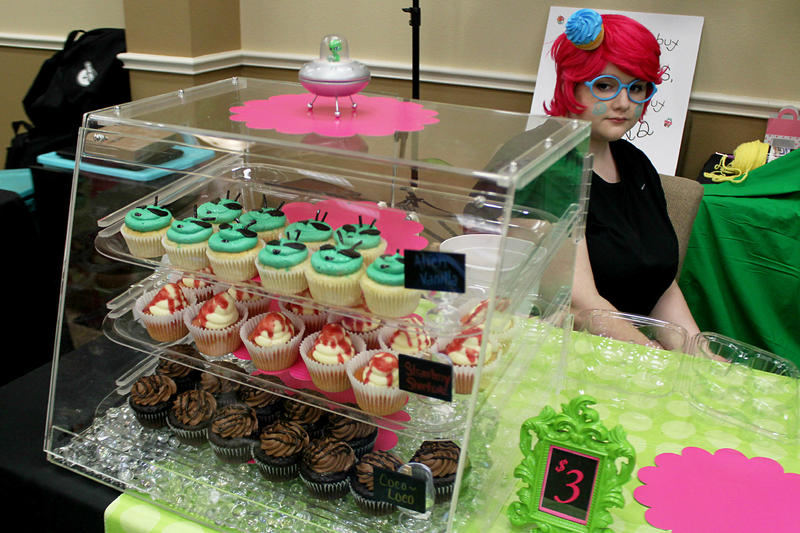 Vendors at a conference in Aurora sold a range of UFO-related books and paraphernalia. Makayla Smith, 17, was selling alien-faced cupcakes.
