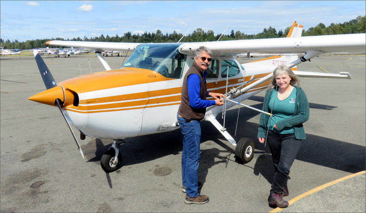 Pilot Jeff Well and biologist Rachael Mueller with the fisher survey plane at Pierce County's Thun Field. Notice the antennas on the wing struts. CREDIT: TOM BANSE / NORTHWEST NEWS NETWORK