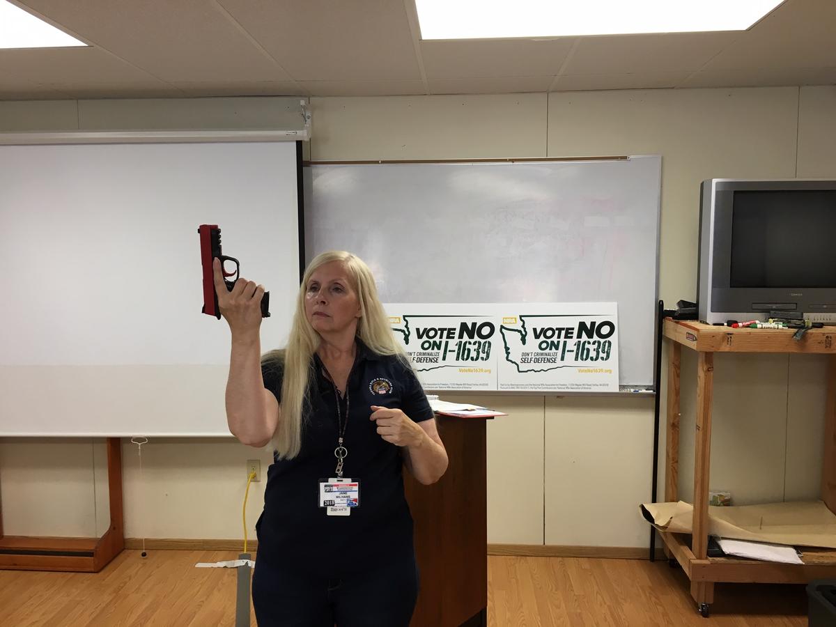 Firearms instructor and I-1639 opponent Jane Milhans demonstrates pistol handing safety at a class for women in University Place, Washington. CREDIT: AUSTIN JENKINS / NW NEWS NETWORK