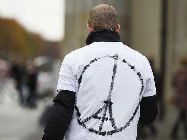 A man wears a shirt with the "Peace for Paris" symbol, near the French embassy in Berlin on Saturday, a day after the deadly attacks in Paris.
