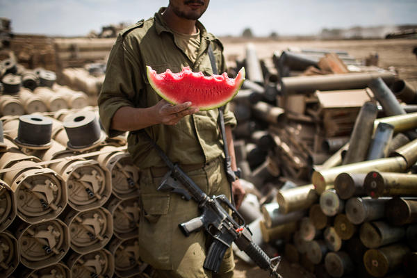 An Israeli soldier eats a piece of watermelon near Israel's border with the Gaza Strip in 2014. As more Israelis go vegan, the country's military has made dietary and clothing accommodations for soldiers.
