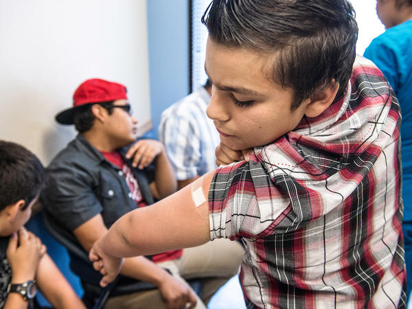 Abraham Vidaurre, 12, checks his arm after receiving an HPV vaccination at Amistad Community Health Center in Corpus Christi, Texas, in 2016. Though gender differences in vaccine rates have narrowed, more girls than boys tend to get immunized against HPV.