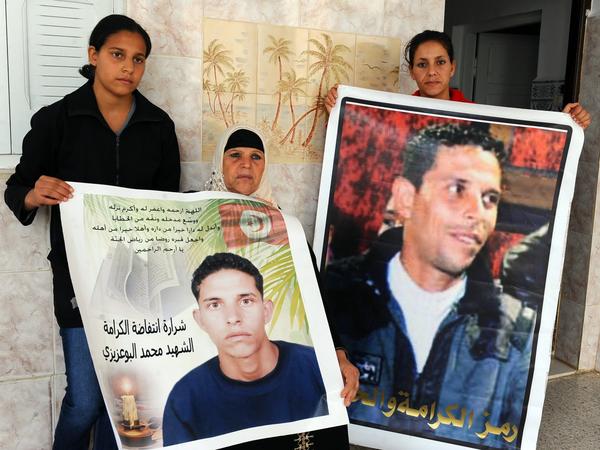 Manoubia Bouazizi (center) holds signs showing her son Mohamed along with her daughters, Basma (left) and Leila, in 2011. Mohamed's self-immolation in December 2010 was part of the impetus to the revolution that later ousted a dictator in Tunisia.