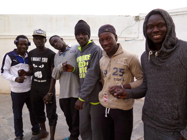 Boubacker Nassou (third from right) lives in a shelter run by the Tunisian Red Crescent aid group that houses men who fled from Libya. Many tell stories of being forced into modern day slavery in Libya.