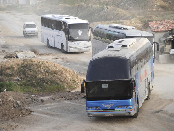 The evacuation by bus of rebel fighters and their families in eastern Ghouta, Syria. Buses from the Syrian Ministry of Transport and Syrian Red Crescent vehicles were seen on the outskirts of Harasta on Thursday, after crossing the last Syrian Army checkpoint before the town.