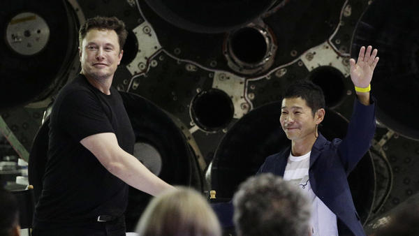 SpaceX founder and chief executive Elon Musk, left, shakes hands with Japanese billionaire Yusaku Maezawa, right, on Monday, after announcing that he will be the first private passenger on a trip around the moon.