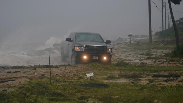 A truck drives along a washed-out road as Hurricane Michael's storm surge and winds come ashore in Alligator Point, Fla., Wednesday.