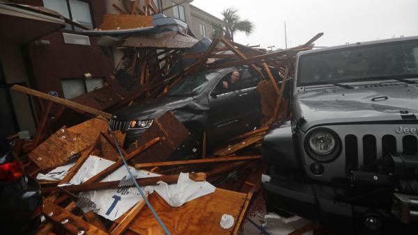 A storm chaser climbs into his vehicle as the eye of Hurricane Michael passes over Panama City Beach, Fla., hoping to retrieve his equipment after a hotel canopy collapsed in the parking area. The storm came ashore as a nearly Category 5 hurricane Wednesday.
