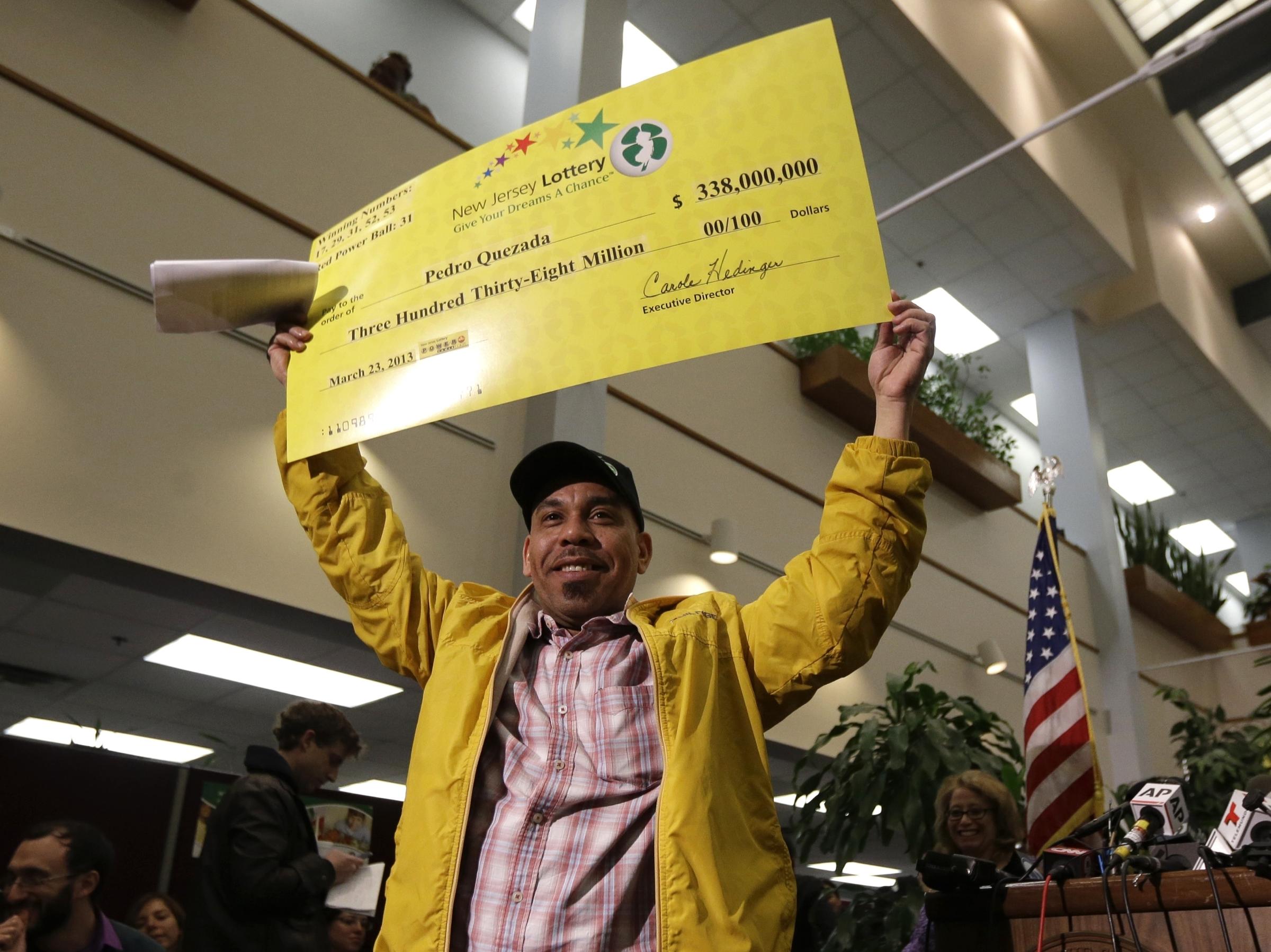 Powerball winner Pedro Quezada holds up a promotional check featuring his $...