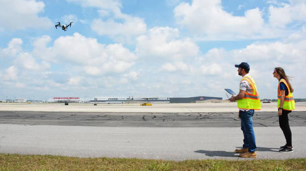 Jim Duguay and Katie Eleam pilot a drone over runway 27R at Hartsfield-Jackson Atlanta International Airport.