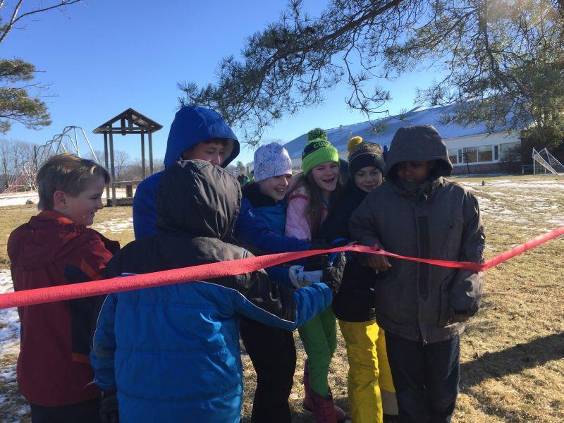 Members of the sixth-grade class at Bingham Memorial School in Cornwall cut a ceremonial ribbon, officially opening their new "loose-parts" playground. It's full of things like stumps and hay, so kids of all ages can build and create together.