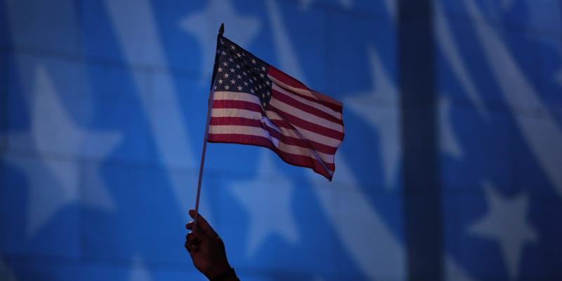 Howard Nizebeth waves a U.S. flag during an Election Day gathering at Rockefeller Center, Tuesday, Nov. 8, 2016, in New York.