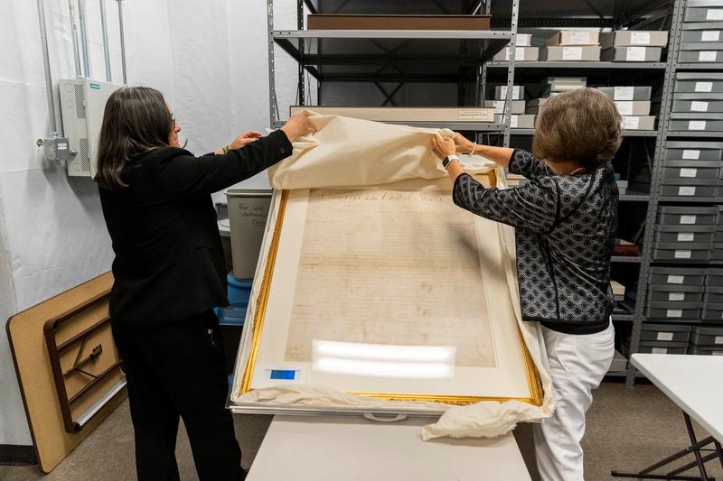 From left, Deputy Attorney General Karen Blum and state Archivist Sarah Koonts reveal North Carolina's copy of the Bill of Rights.