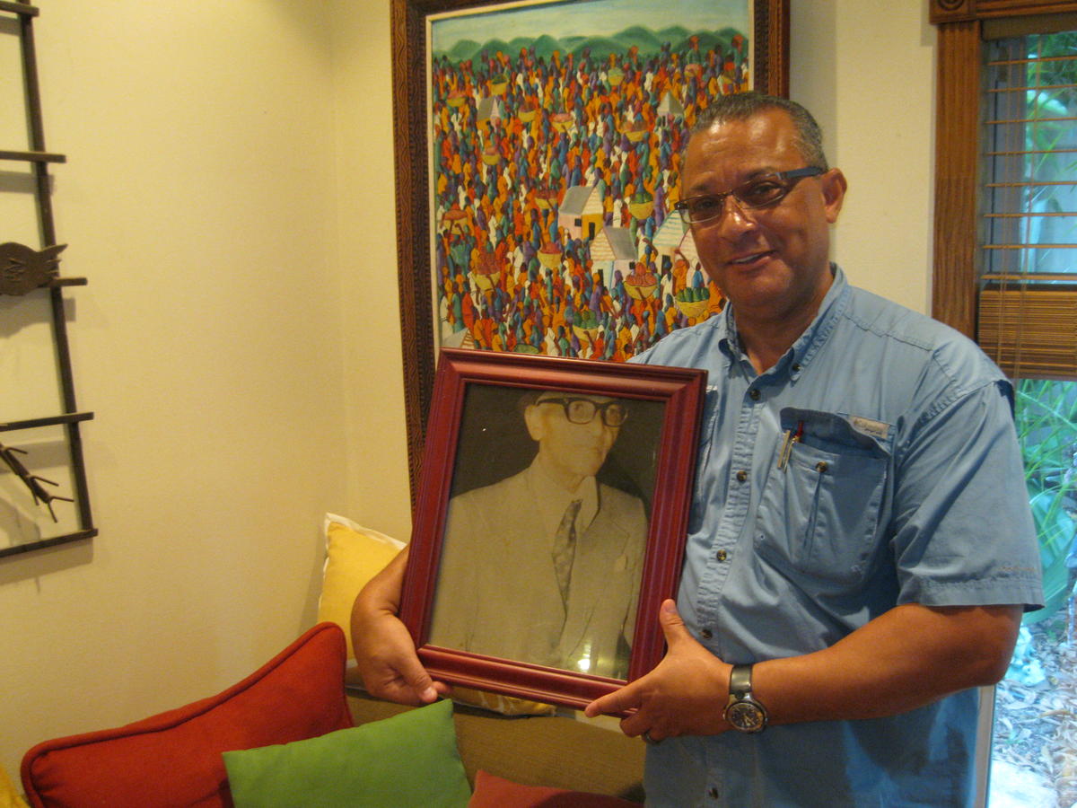 Serge Jean-Louis with a photo of his Haitian grandfather.