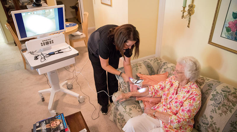 Eleanor Grayson is examined with a telehealth machine in her home at The Village at Summerville.