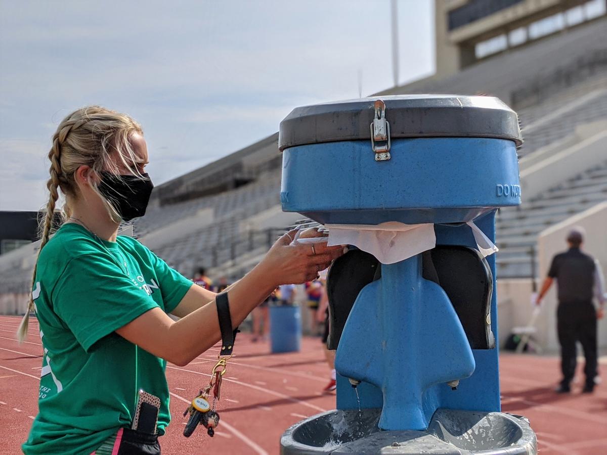 Students were required to wash their hands before taking and leaving the field during Wichita State University’s Clash of the Colleges. (Photo by Stephan Bisaha, Kansas News Service)