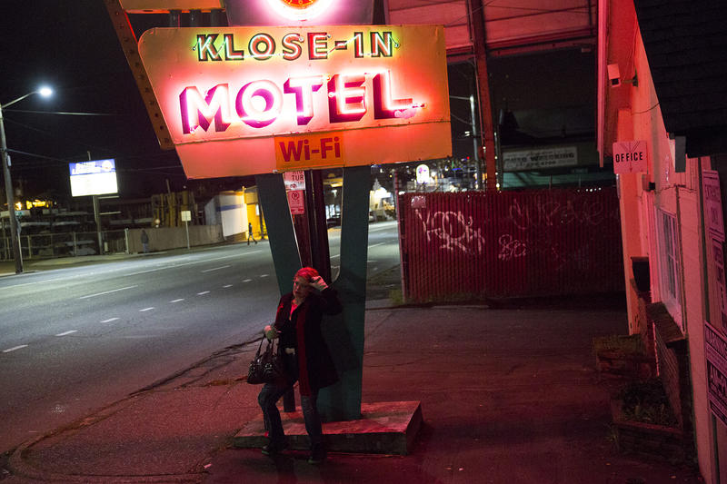 Ericka, then 36, stands outside a motel on Aurora Avenue North in Seattle in 2015. The motel has since been torn down.