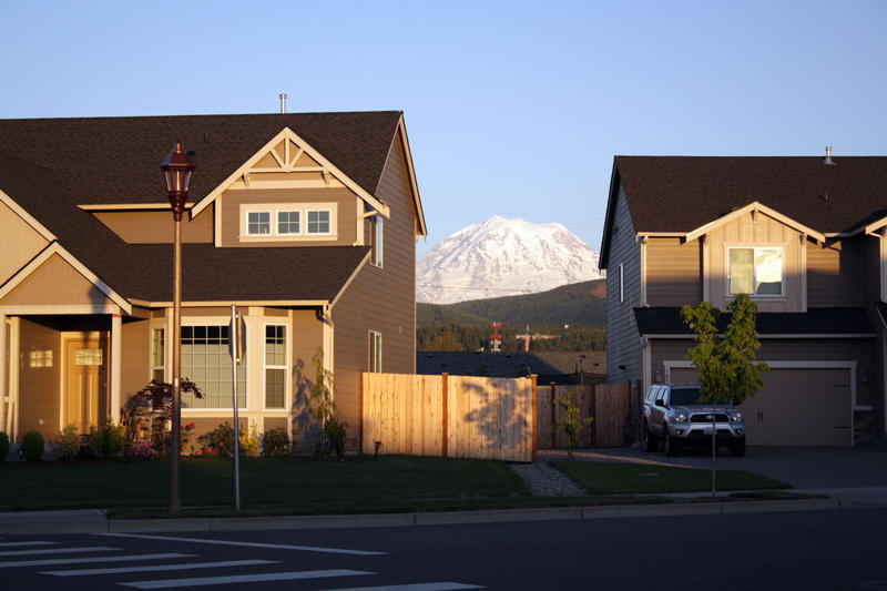 Mt. Rainier peeks between two houses in Orting, Washington.