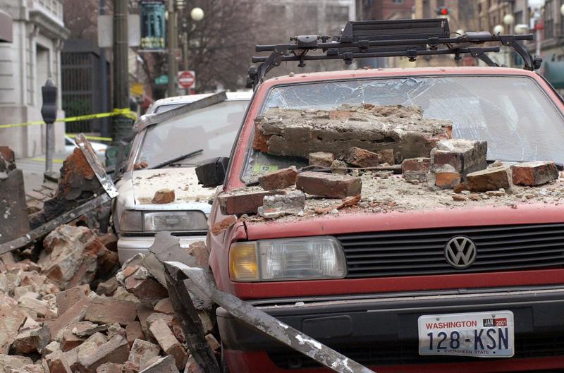 Bricks that fell from an earthquake cover parked cars in Seattle's Pioneer Square district, Wednesday, Feb. 28, 2001 after a magnitude 6.8 earthquake which damaging buildings and roads, and closing Seattle's two airports.