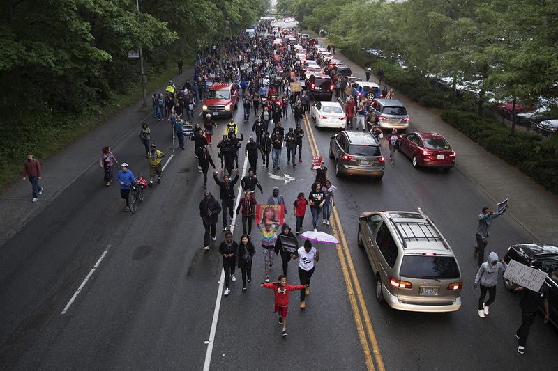 A large crowd marches on Montlake Blvd. after a vigil honoring Charleena Lyles was held at Solid Ground Brettler Family Place on Tuesday, June 19, 2017, in Seattle, Washington. 