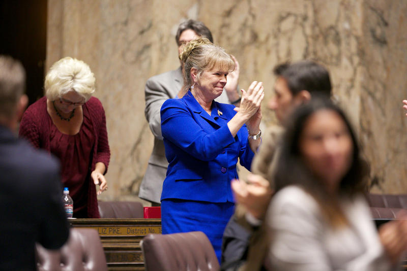 Washington state Rep. Judy Warnick applauds after the capital budget is adopted as the last bill of the 2013 session