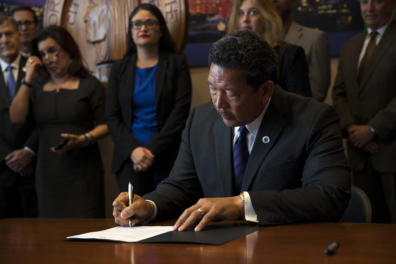 Seattle City Council President Bruce Harrell signs an executive order on Wednesday, September 13, 2017, after taking the oath of office and becoming the mayor of Seattle at City Hall.