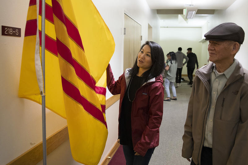 Thanh Tan stands with her father, Duc Tan, as they look at the South Vietnamese flag, at Hung Vuong Vietnamese Language School inside the Lutheran Church of the Good Shepherd on Friday, September 29, 2017, in Olympia. 