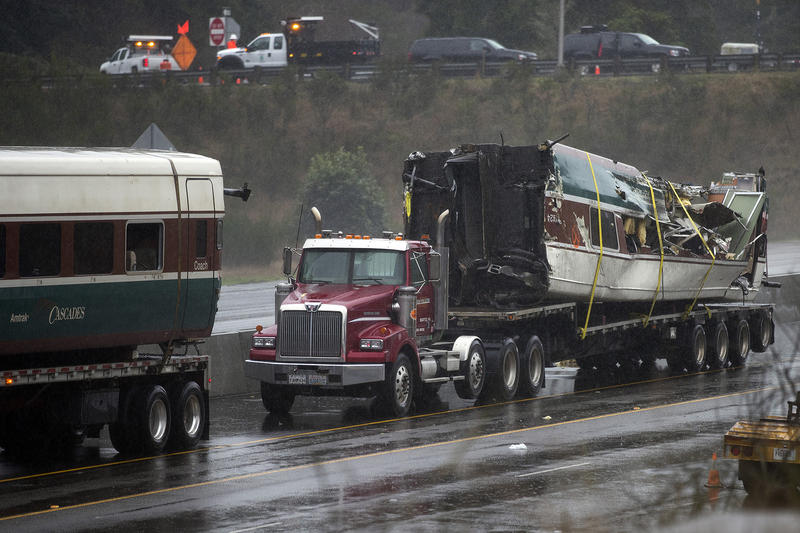 A damaged train car is shown on the bed of a truck along I-5 South on Tuesday, December 19, 2017, in Dupont. 