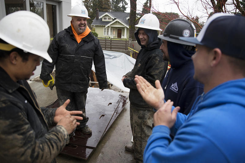 From left, Anthony Banks, Zack Larson, Chris Chase, Devin Ottesen and James Kennemer laugh while working on a job site on Tuesday, January 9, 2018, on 38th Ave East in Seattle.