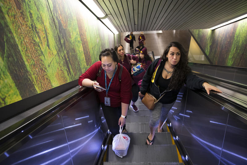 Tanya Jose, left, and Leilani Kaaiwela-Pedreira ride the escalator at Seattle-Tacoma International Airport before flying to Hilo on Friday, March 30, 2018. 