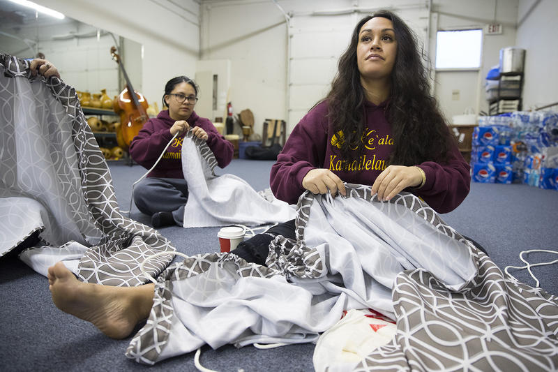 Leilani Kaaiwela-Pedreira, center, and Jessica Whalen, left, assemble their traditional Kahiko dresses on Thursday, March 22, 2018, at the halau in Federal Way. 