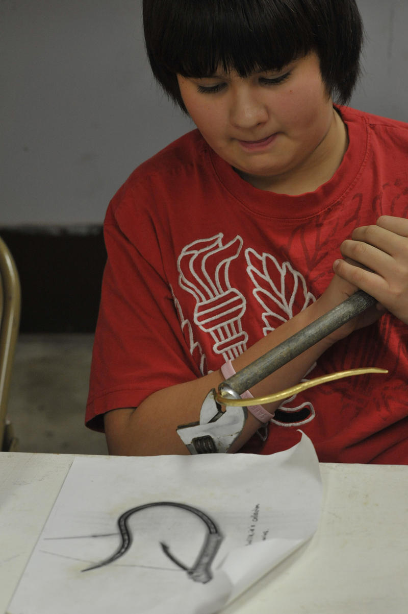Makah volunteer Ollie Kallappa, Jr., bending a cibud into shape