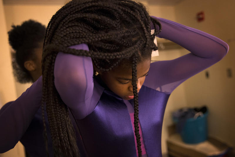 Yizjuani Watson, 11, has help with her costume from Simya Gibson, 13, during a rehearsal on Tuesday, May 15, 2018, at Rainier Beach high school in Seattle.