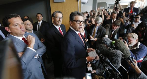 Governor Rick Perry addresses reporters outside a Travis County courtroom earlier this month.