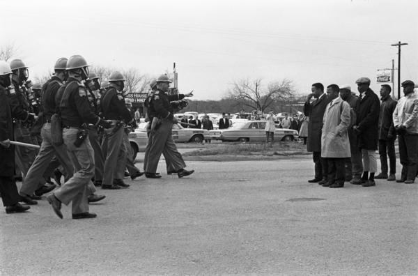 Spider Martin's most well-known photograph, <em>Two Minute Warning,</em> shows marchers facing a line of state troopers in Selma moments before police beat the protestors on March 7, 1965. The day became known as Bloody Sunday.