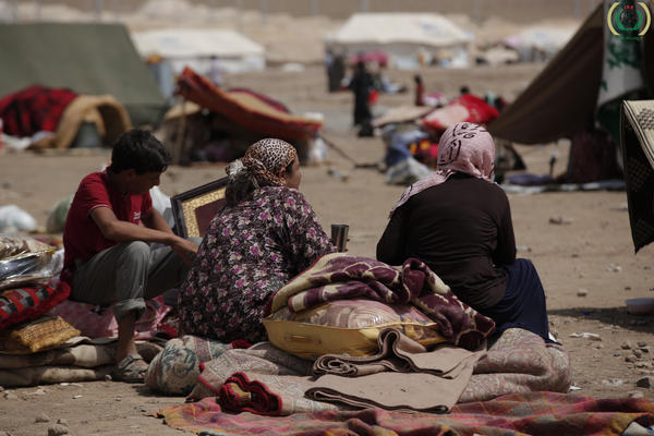 Syrian refugees sit among their belongings in the Kawrgosk refugee camp in Irbil, Northern Iraq.