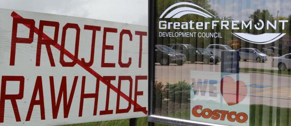 Signs for and against construction of a proposed Costco chicken processing plant, nicknamed Project Rawhide.