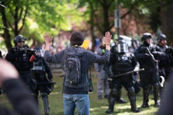 <p>A counter-protester named Anthony holds his hands in the air after being hit with pepper balls by Portland police Sunday, June 4, 2017.&nbsp;</p>