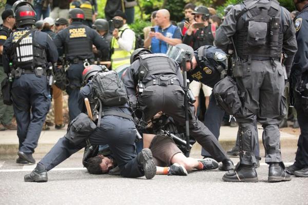 <p>Portland police arrest a protester who skated past a police barricade during an afternoon of protests in downtown Portland on Sunday, June 4, 2017.&nbsp;</p>