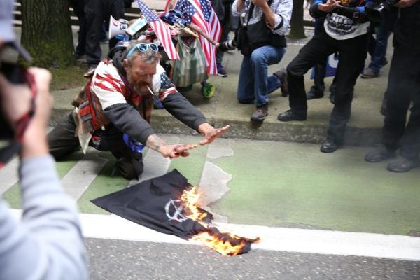 <p>A Portland man known as Pork Chop burns an Antifa flag at a Trump Free Speech Rally Sunday, June 4, 2017.</p>