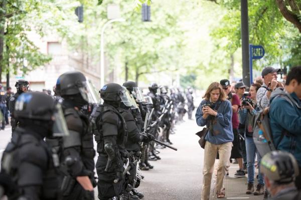 <p>Police dressed in riot gear formed barricades between opposing protest groups, restricting movement between downtown Portland streets Sunday, June 4, 2017.</p>