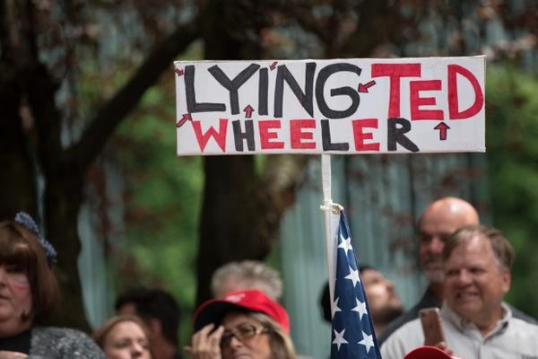<p>A protester at the Trump Free Speech Rally holds up a sign in opposition to Portland Mayor Ted Wheeler Sunday, June 4, 2017. One thing both the pro-Trump crowd and the crowd of counter-protesters shared in common was animosity for Portland's mayor.&nbsp;</p>