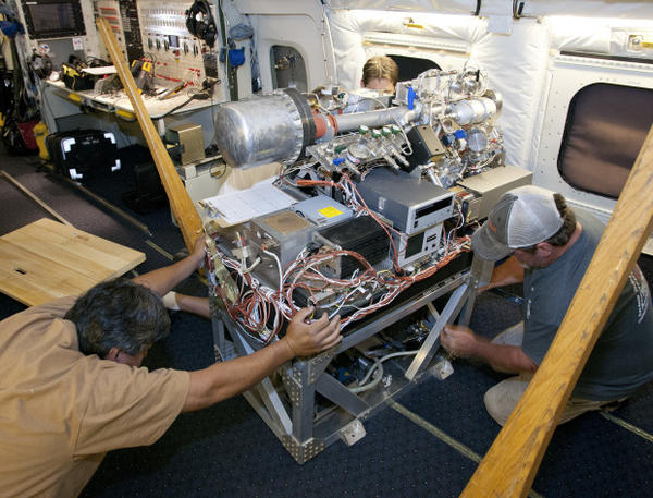 <p>Researchers work on instruments inside a specially outfitted plane.</p>