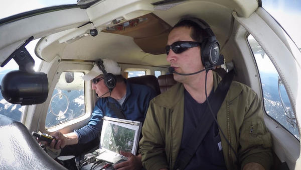 <p>Jeff Lewis (left) listens for signals from below his airplane indicating the presence of fishers below in the Gifford Pinchot National Forest.</p>