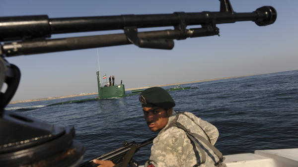A member of Iran's navy participates in a drill on Dec. 28, 2011, in the Sea of Oman. Tehran is threatening to close the strategic Strait of Hormuz at the mouth of the Persian Gulf, in retaliation for new sanctions by the West.