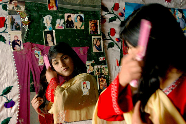 An Afghan girl brushes her hair in Kabul, 2007.