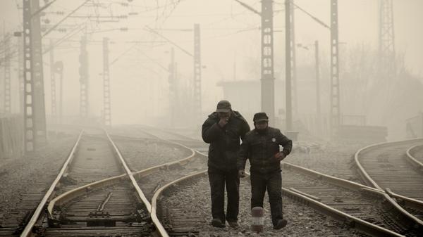 Men walk along a railway line in Beijing on Jan. 12, as air pollution reached hazardous levels.