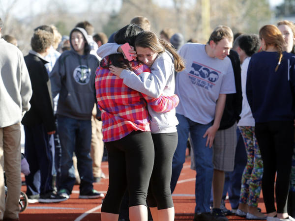 Students comfort each other at Arapahoe High School on Friday.