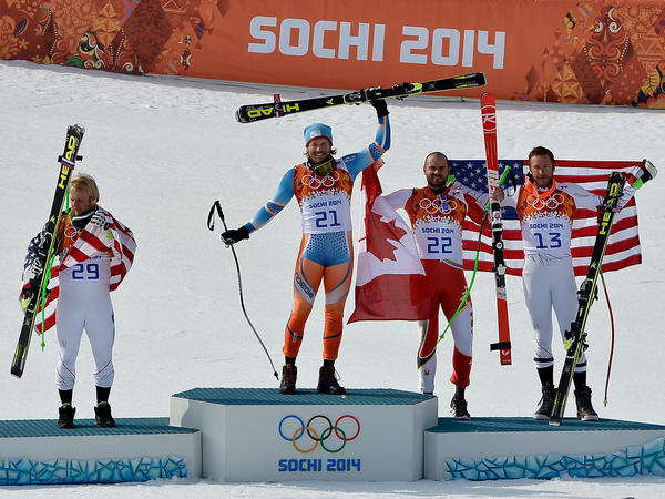 Silver medalist Andrew Weibrecht of the United States, gold medalist Kjetil Jansrud of Norway and bronze medalists Jan Hudec of Canada and Bode Miller of the United States celebrate on the podium during the flower ceremony for the Alpine Skiing Men's Super-G.