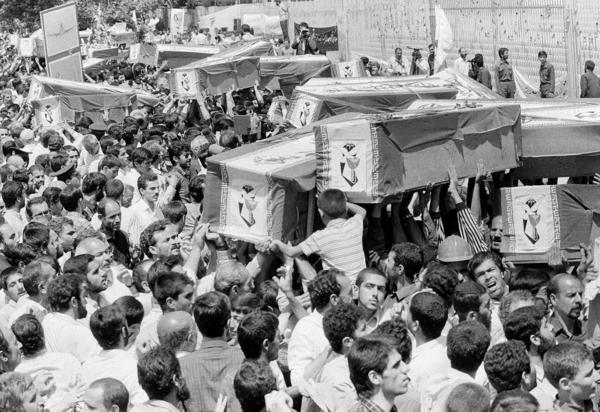 Mourners carry coffins through the streets of Tehran, Iran, on July 7, 1988, during a mass funeral for victims of a downed Iran Air flight. The U.S. Navy shot down the civilian plane in the Persian Gulf, killing all 290 onboard, after mistaking it for an Iranian warplane.